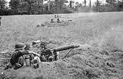 June 1944, near Tilly Sur Seulle, Normandy, France. George is in the center firing the Vickers.