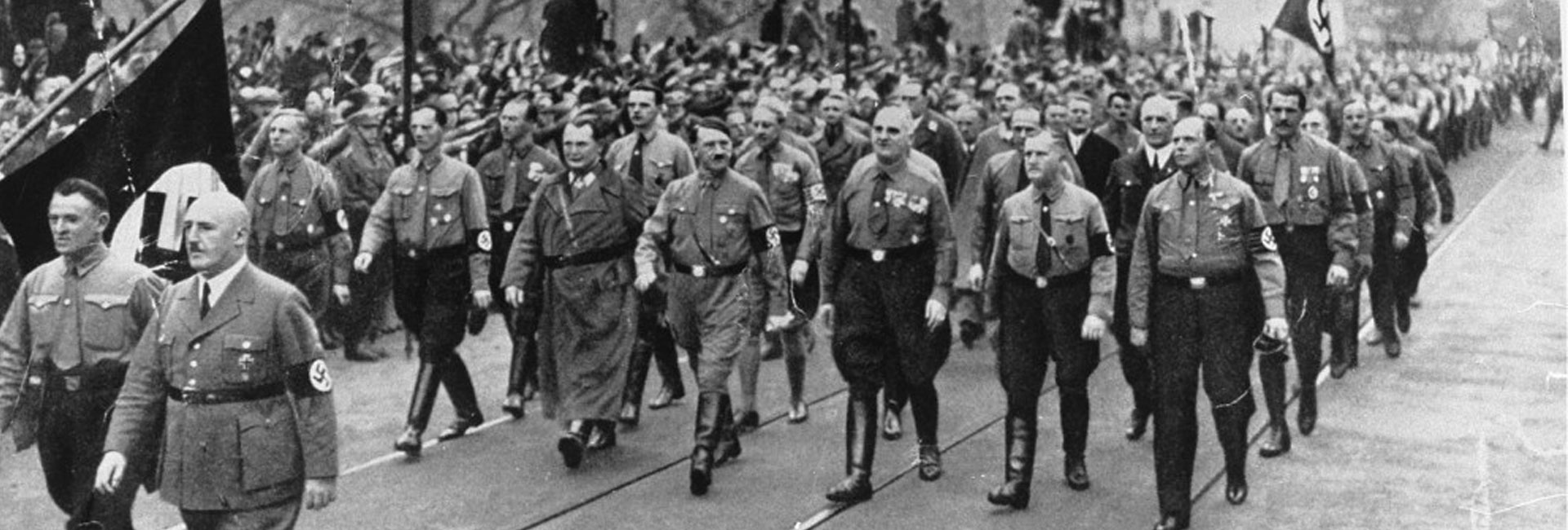 Adolf Hitler (centre), Julius Streicher (foreground, right) and Hermann Göring (left of Hitler) retrace the route of the failed Beer Hall Putsch during its annual commemoration in Munich, Germany, on 9 November 1934. The Nazi regime transformed the failed coup of 1923 into one of its founding myths, using the anniversary to honour the sixteen Nazi supporters killed during the march and to reinforce loyalty to the Party.